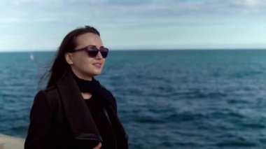 Kadın güneş gözlüğü yavaş deniz ile arka plan üzerinde yürüme