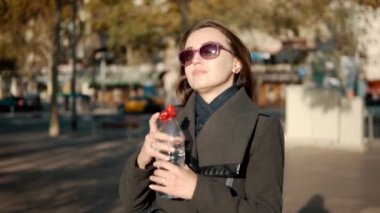 şişe ve içme suyu açık havada açılış susamış bir iş kadını. Slowmotion atış