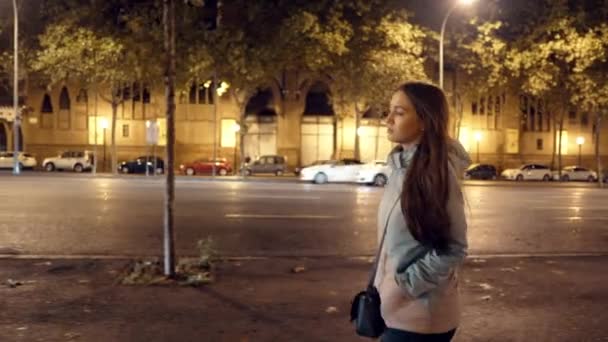 Trött tjej går på en mörk gata efter jobbet. Stadens nattliv — Stockvideo