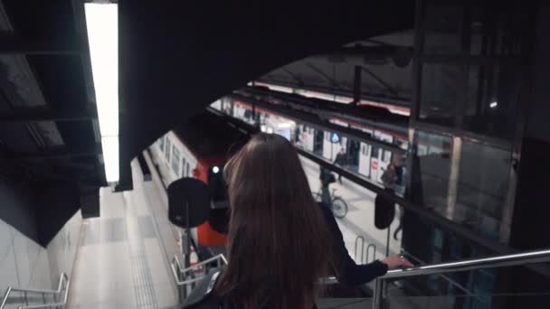 Молодая привлекательная женщина изящно спускается по эскалатору метро — стоковое видео