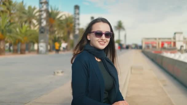 Unga turist kvinna sitter nära palm beach och leende — Stockvideo