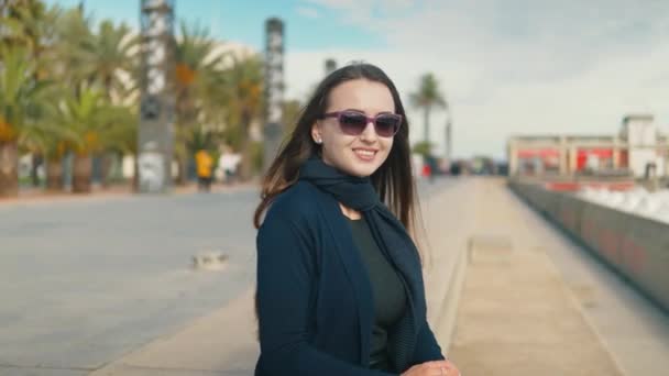 Joven turista sentada cerca de la playa de la palma y sonriendo — Vídeos de Stock