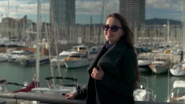 Woman in sunglasses walking with a lot of yachts and boats behind — Stock Video