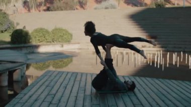 Güzel çift acro yoga sabah açık havada şehirde uygulamak. Denge ve bağlantı kavramı.