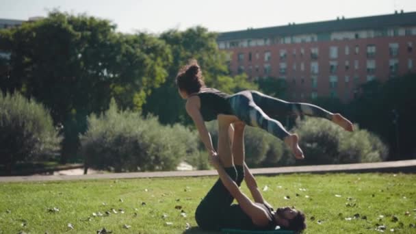 Hermosa pareja practicando acro yoga por la mañana — Vídeo de stock