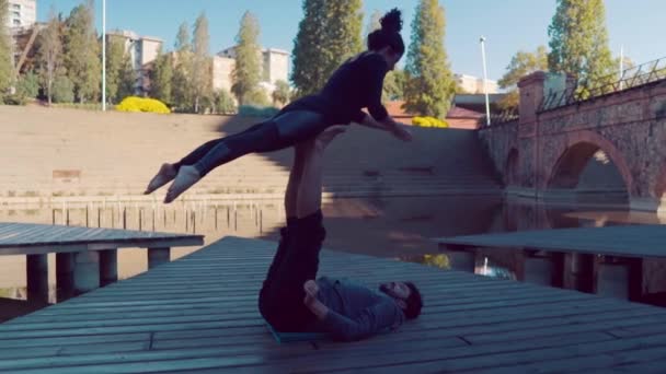 Hermosa pareja practicando acro yoga por la mañana — Vídeo de stock