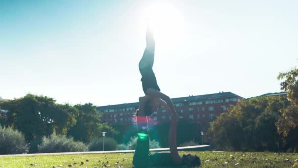 Hermosa pareja practicando acro yoga por la mañana — Vídeos de Stock