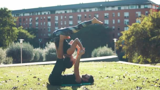 Hermosa pareja practicando acro yoga por la mañana — Vídeos de Stock