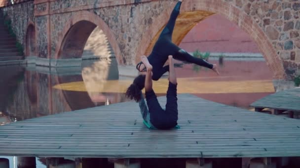 Mooie paar acro yoga beoefenen in de ochtend — Stockvideo