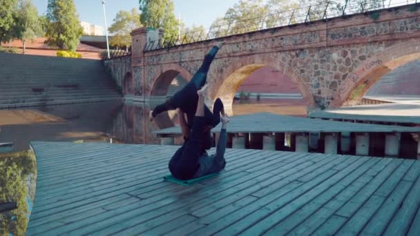 Hermosa pareja practicando acro yoga por la mañana — Vídeo de stock