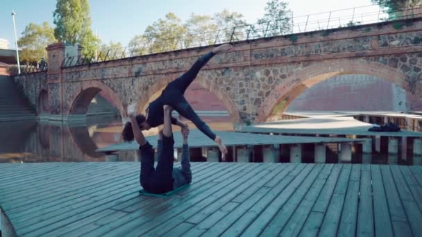 Hermosa pareja practicando acro yoga por la mañana — Vídeos de Stock