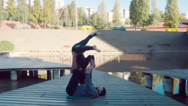 Hermosa pareja practicando acro yoga por la mañana — Vídeo de stock