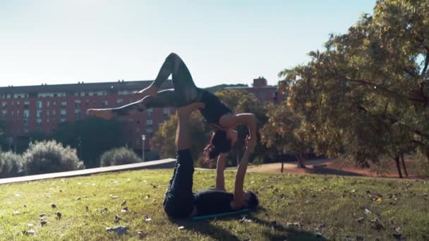 Hermosa pareja practicando acro yoga por la mañana — Vídeo de stock