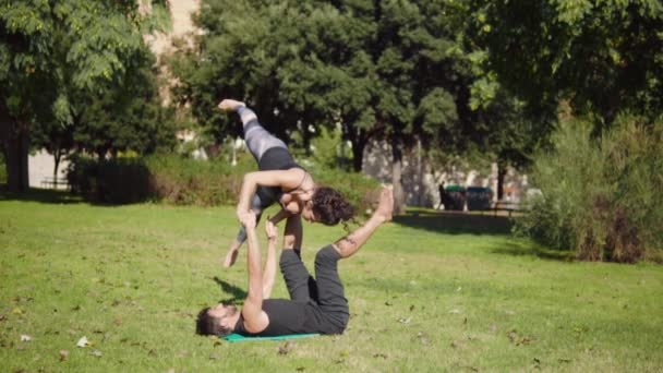 Schönes Paar Das Morgens Akro Yoga Auf Der Rasenfläche Praktiziert — Stockvideo