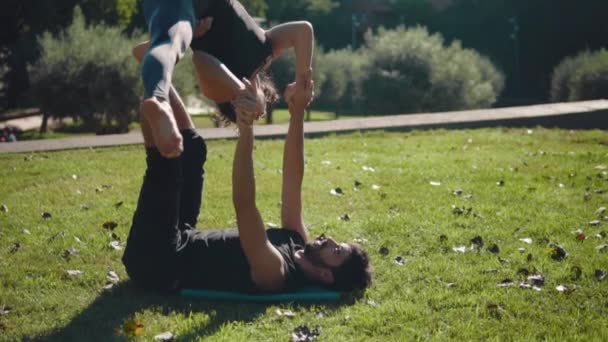 Hermosa pareja practicando acro yoga por la mañana — Vídeos de Stock