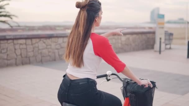 Donna in bicicletta lungo la spiaggia di sabbia durante l'estate — Video Stock