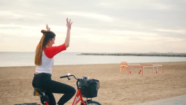 Mujer montar en bicicleta a lo largo de la playa de arena en verano — Vídeos de Stock