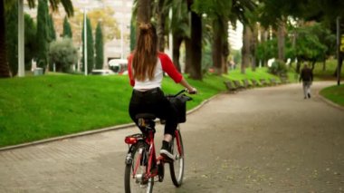 palmiye ağaçlarının yanında pedal genç kadın veya kız binicilik bisiklet