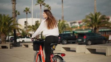 palmiye ağaçlarının yanında pedal genç kadın veya kız binicilik bisiklet