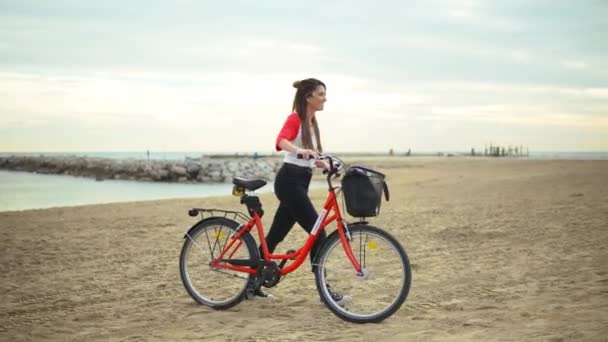 妇女骑自行车沿海滩沙子在夏天时间 — 图库视频影像