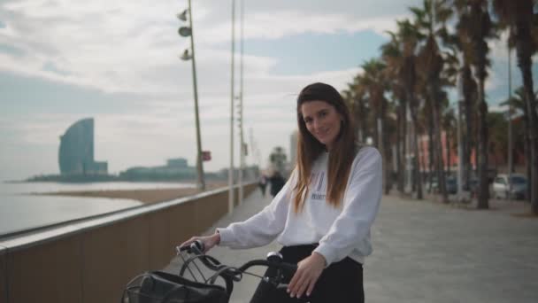 Kvinna Rider cykel längs stranden vid sommartid — Stockvideo