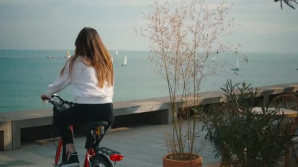 Donna in bicicletta lungo la spiaggia durante l'estate — Video Stock