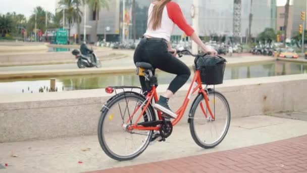 Молодая женщина или девушка на велосипеде педали рядом с пальмами — стоковое видео