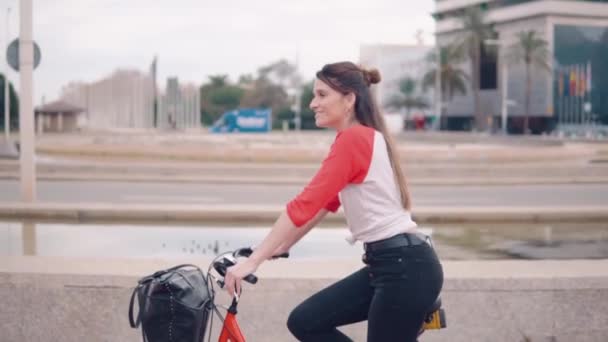Молодая женщина или девушка на велосипеде педали рядом с пальмами — стоковое видео