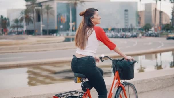 Jeune femme ou fille à vélo pédalant à côté de palmiers — Video