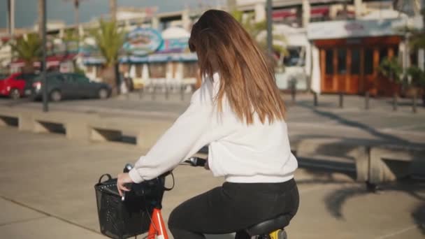 Молода жінка або дівчина катається на велосипеді, що дзвонить поруч з пальмами — стокове відео
