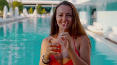 Mutlu kadın yüzme havuzunda egzotik kokteyl içme