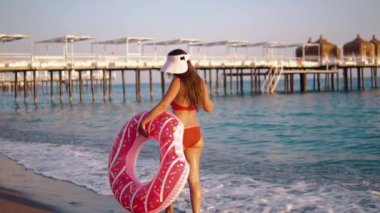 Genç kadın şişme bir çörek ile arka yüzüne yüzen