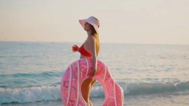 Genç kadın şişme bir çörek ile arka yüzüne yüzen