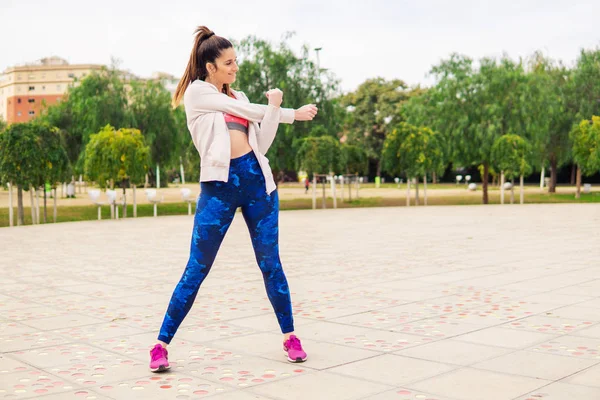 Corredor en forma mujer calentando antes de entrenamiento deportivo en el parque — Foto de Stock