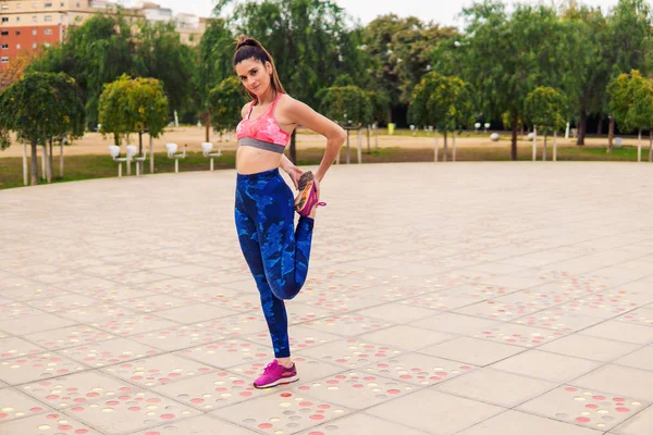 Runner apto mulher aquecendo antes do treinamento esportivo no parque — Fotografia de Stock