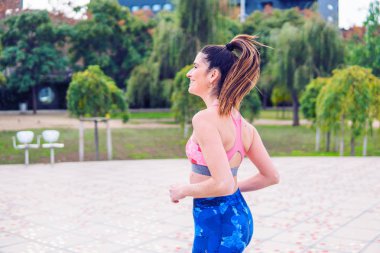 Genç güzel uygun kadın parkta çalışıyor