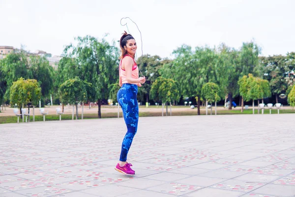 Ajuste hermosa mujer con saltar la cuerda en un parque — Foto de Stock