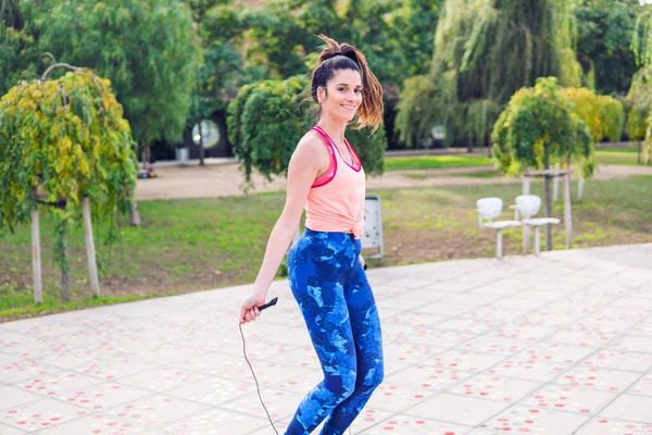 Fit beautiful woman with jumping rope in a park — Stock Photo, Image