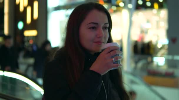 Zeitlupenaufnahme eines Mädchens, das in der Nacht in der Stadt Kaffee schlürft — Stockvideo