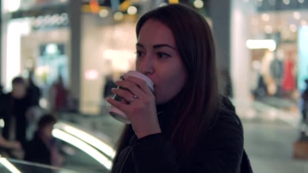 Tikje schot van een meisje dat SIP's koffie in de stad van de nacht — Stockvideo