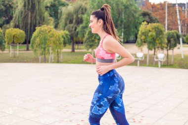 Genç güzel uygun kadın parkta çalışıyor