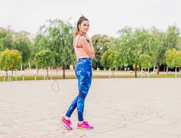 Ajuste mulher bonita com corda de salto em um parque — Fotografia de Stock