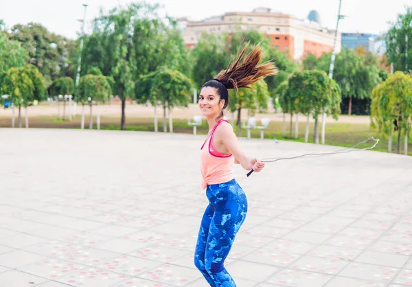 Ajuste hermosa mujer con saltar la cuerda en un parque — Foto de Stock