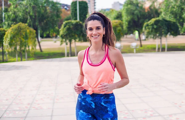 Joven hermosa mujer en forma está corriendo en el parque — Foto de Stock