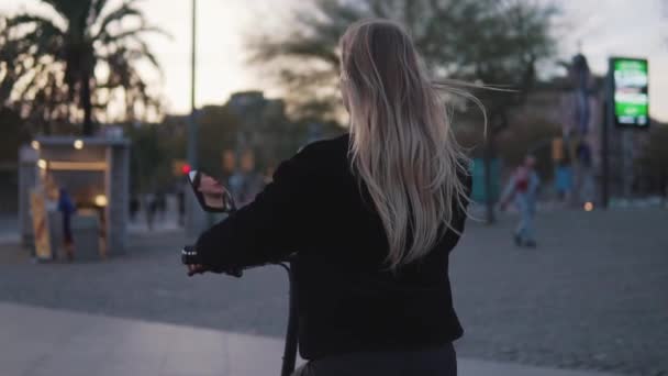Jolie femme blonde conduisant un vélo électrique en ville — Video