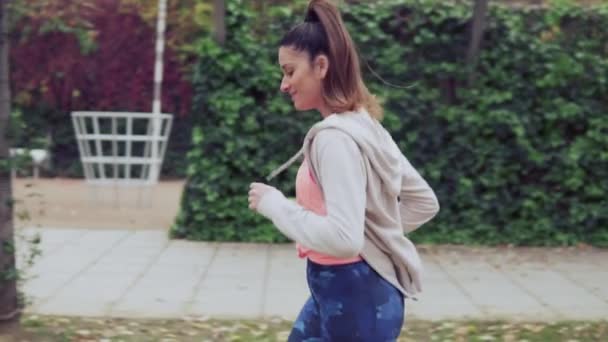 Vídeo en cámara lenta de una mujer en forma corriendo por el parque. entrenamiento deportivo — Vídeos de Stock