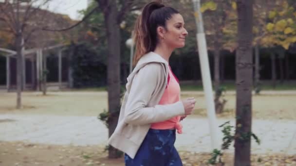 Vídeo en cámara lenta de una mujer en forma corriendo por el parque. entrenamiento deportivo — Vídeos de Stock