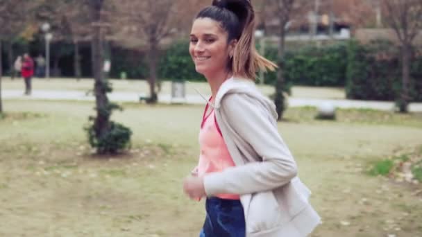 Vídeo en cámara lenta de una mujer en forma corriendo por el parque. entrenamiento deportivo — Vídeos de Stock