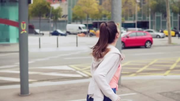 Женщина бегает по улицам города со зданиями на заднем плане — стоковое видео