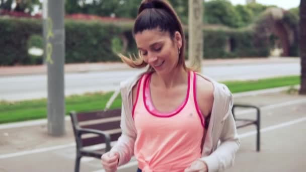 Mujer corriendo en la calle de la ciudad con edificios en el fondo — Vídeo de stock